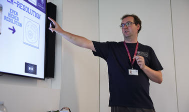 Dr Andrew Frawley pointing to a slide about super-resolution microscopy